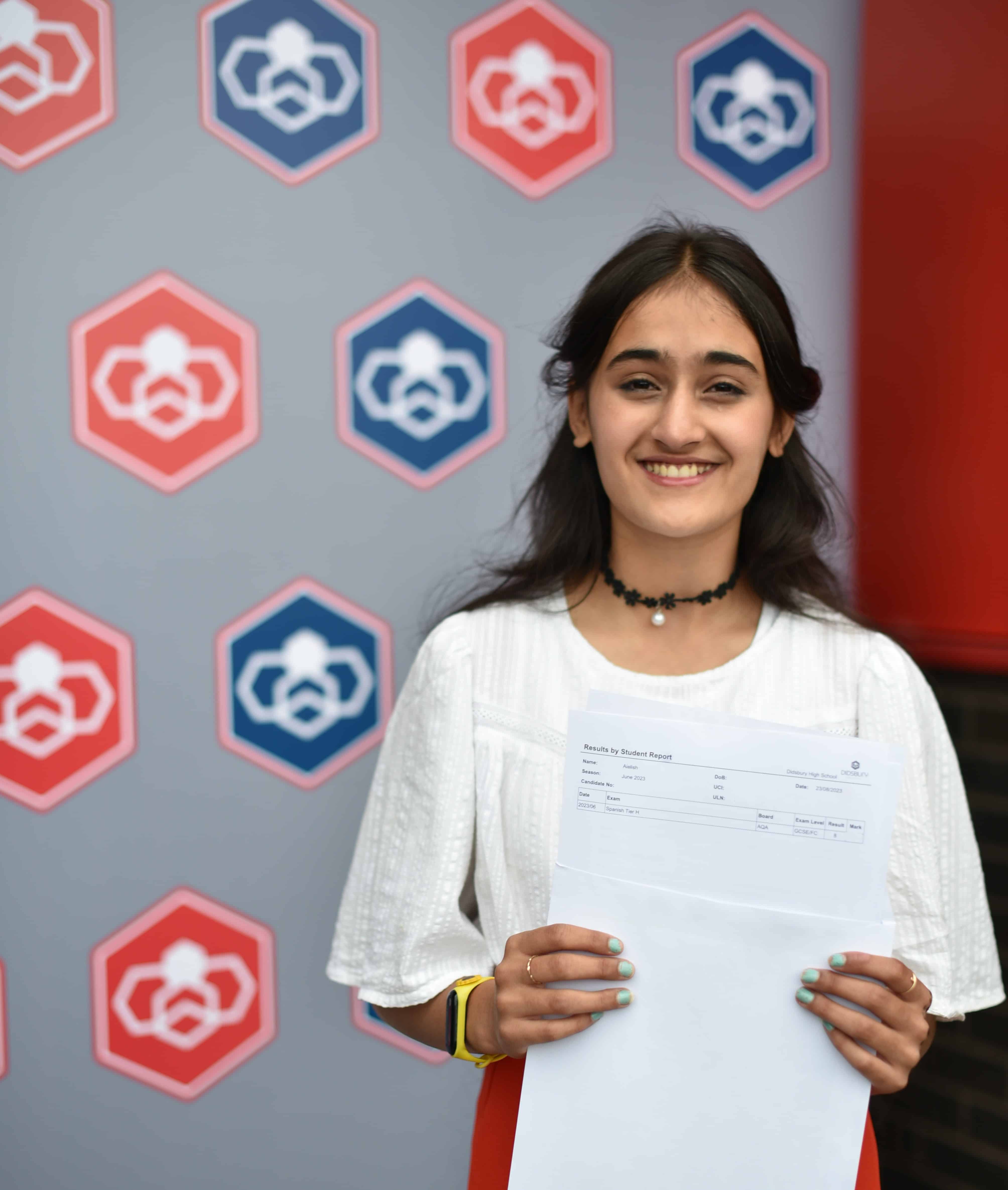 A Didsbury High School student holds her GCSE results and smiles