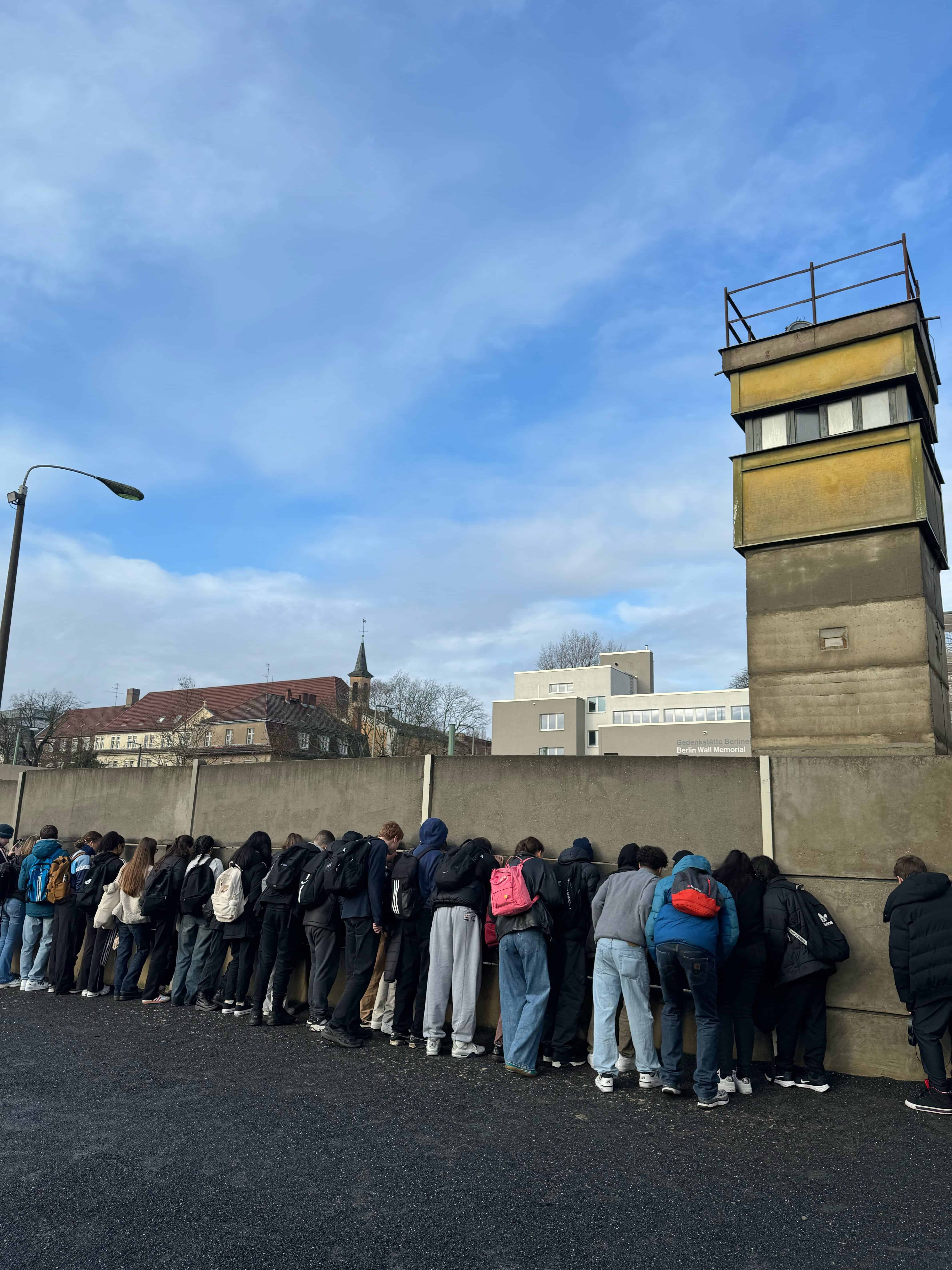 Students from Didsbury High School at the Berlin Wall memorial next to a watchtower