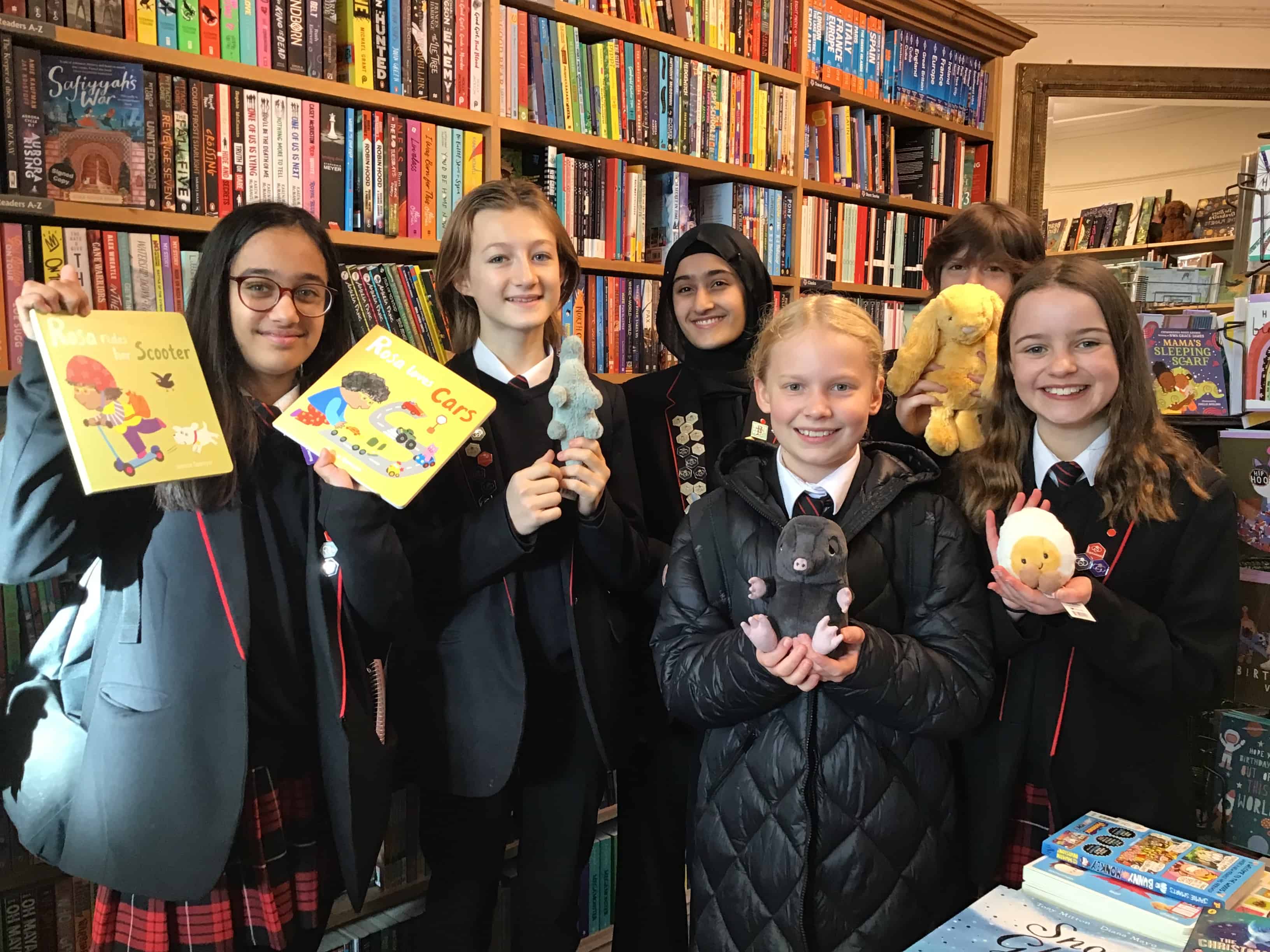 A group of student librarians from Didsbury High School hold books at Chorlton Bookshop.