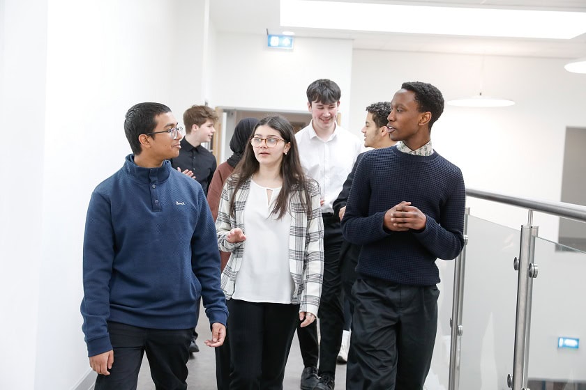A group of students walk along a corridor in Didsbury Sixth Form