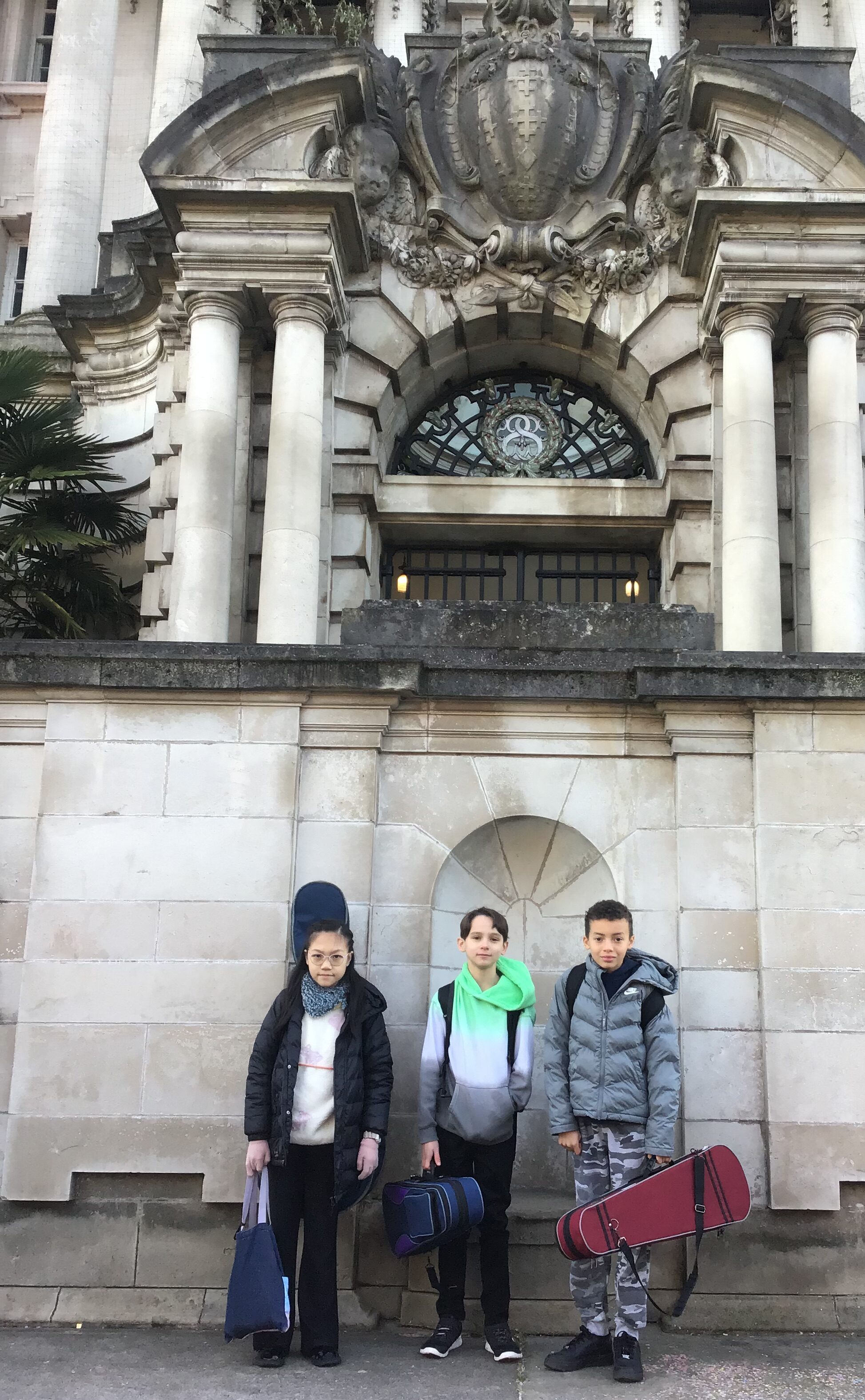 Three students from Didsbury High School stand outside Stockport Town Hall for the Benedetti Foundation Strings day.