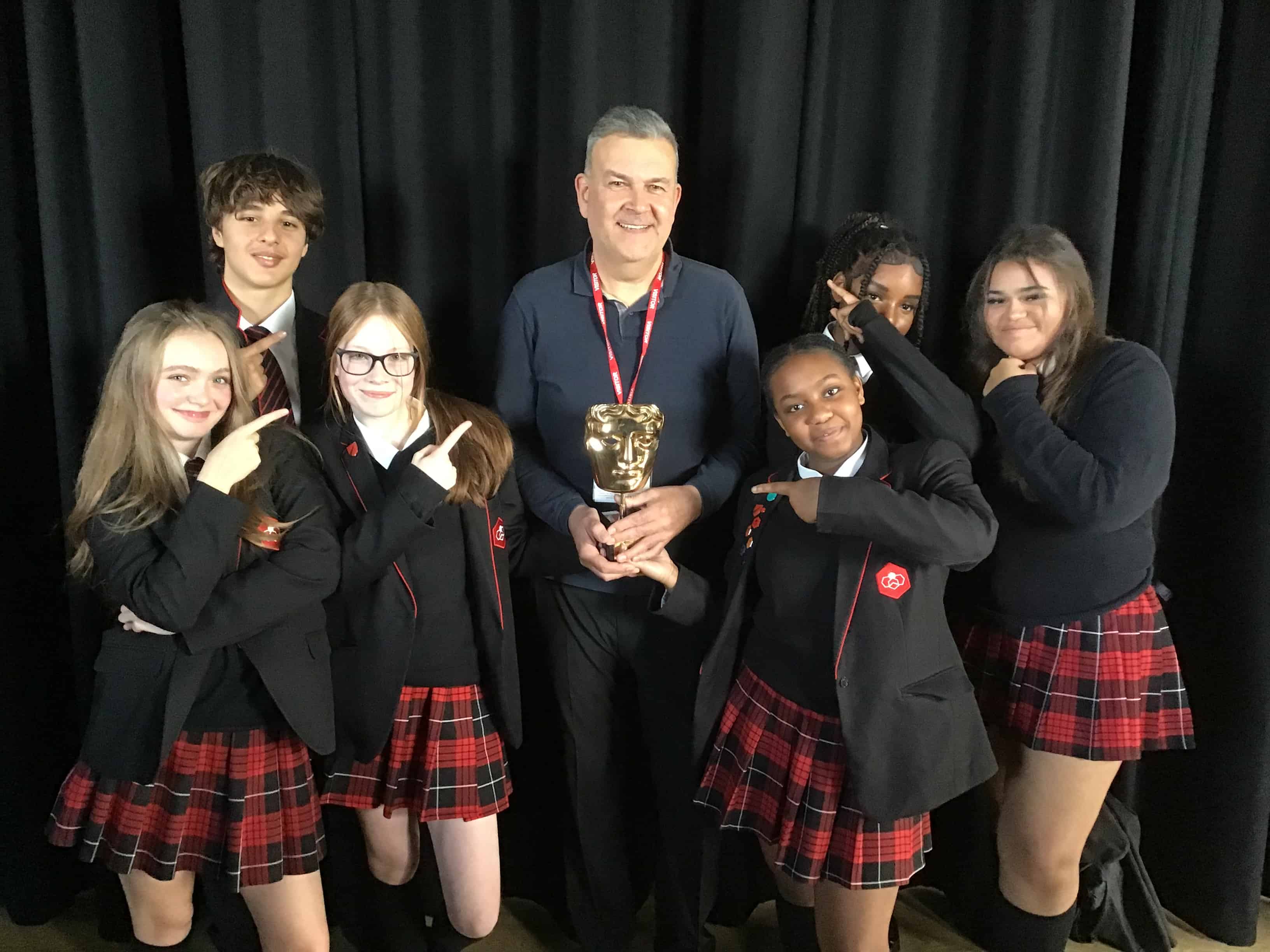 6 students from Didsbury High School pose with Phil Mealey and his BAFTA award.
